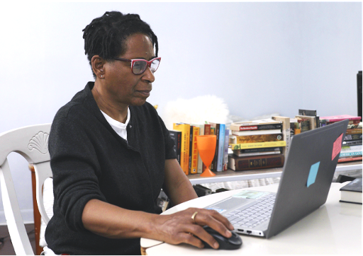 Older black woman working on a laptop and using a mouse