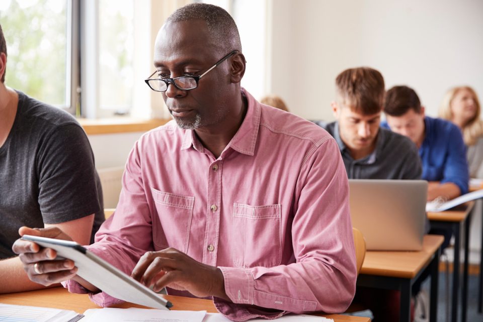 Older Black Male Student Using Digital Tablet In Adult Education Class