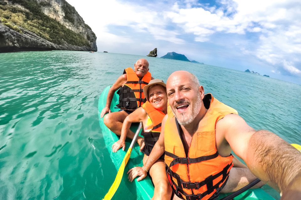 Senior friends taking selfie at kayak excursion in Thailand