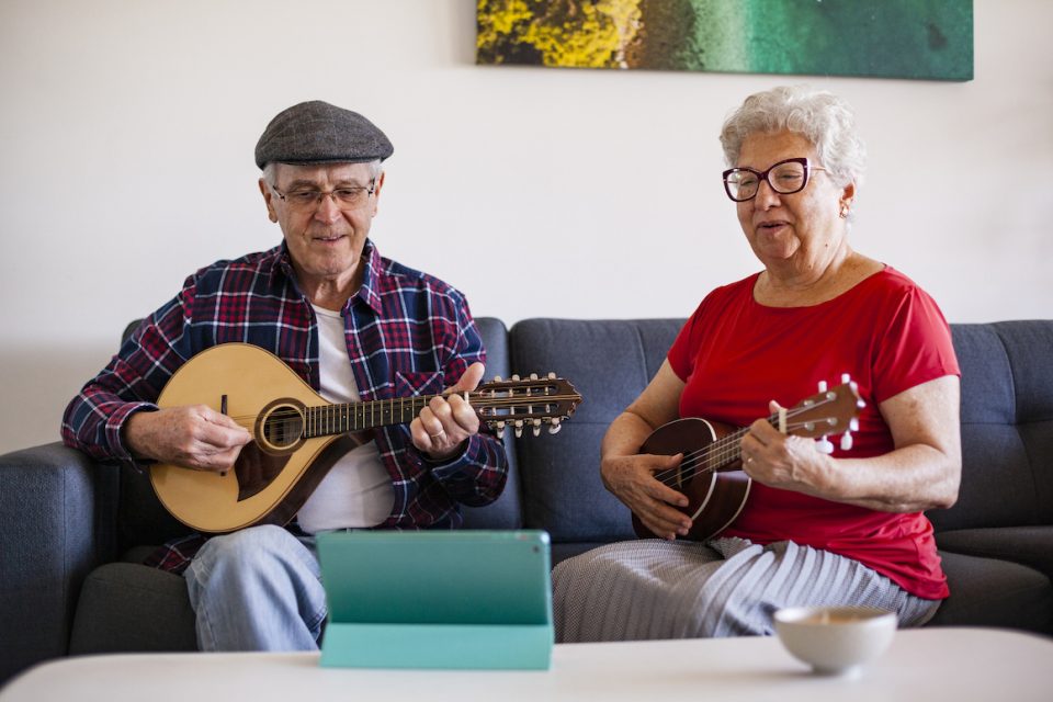 Senior man playing mandolin and senior woman playing ukulele