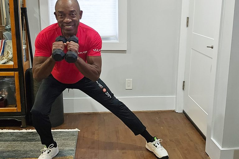 senior african american man exercising with weights squatting to side