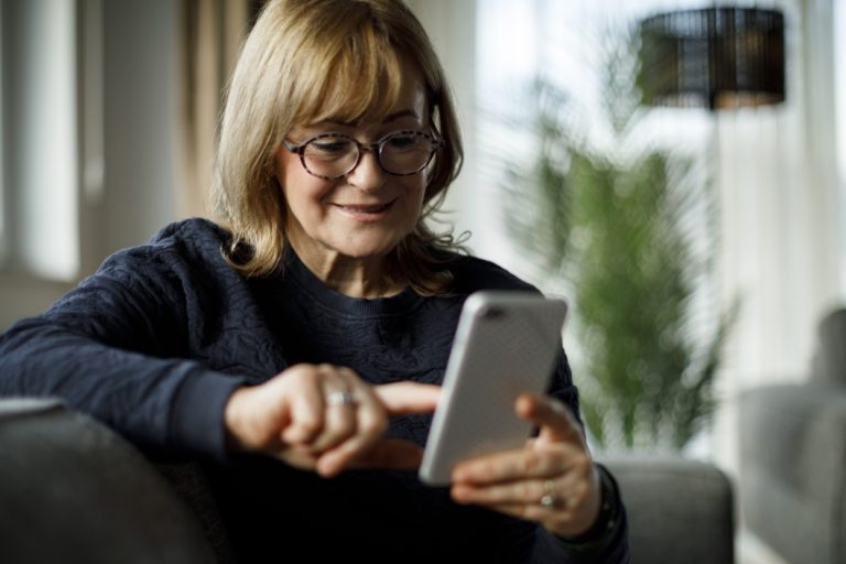 Woman holding her smartphone and touching the screen.