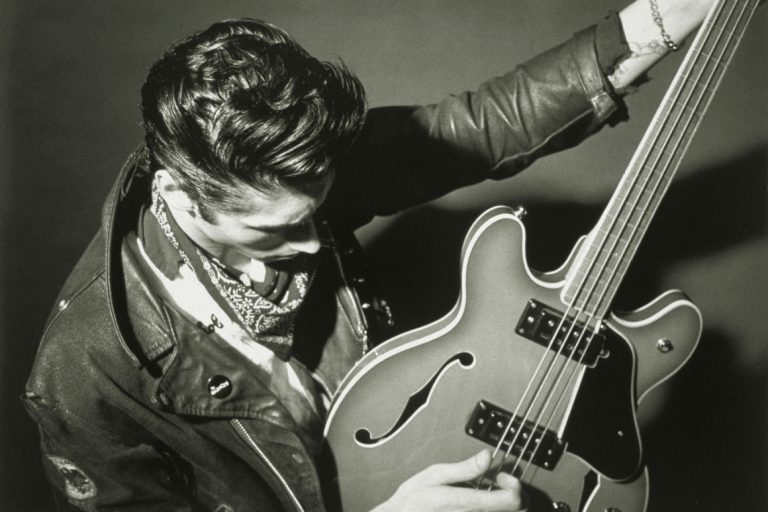 Black and white photo of a man rocking out on a bass guitar.