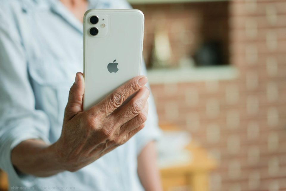 older woman holding iPhone in hand