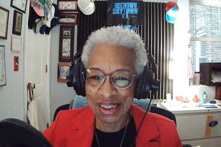 Podcast host Sheila Solomon at the microphone with headphones