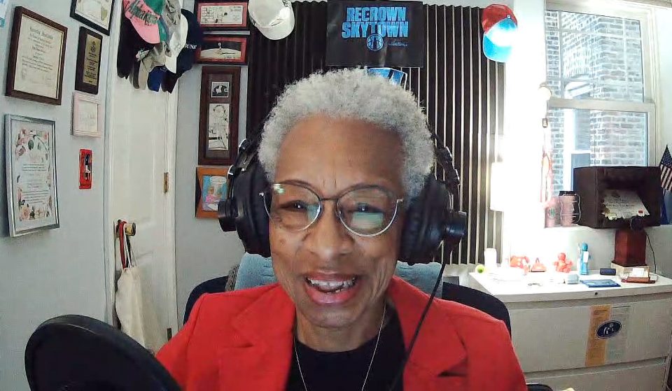 Podcast host Sheila Solomon at the microphone with headphones