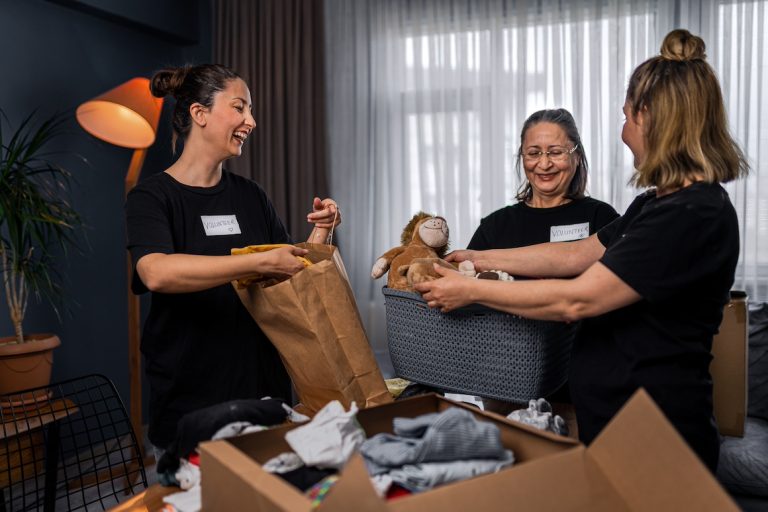Volunteers preparing box of donations for charity