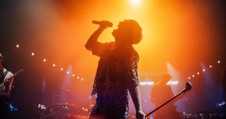 Energetic Rock Band Performing on a Nightclub Stage with Dynamic Lights and Special Effects