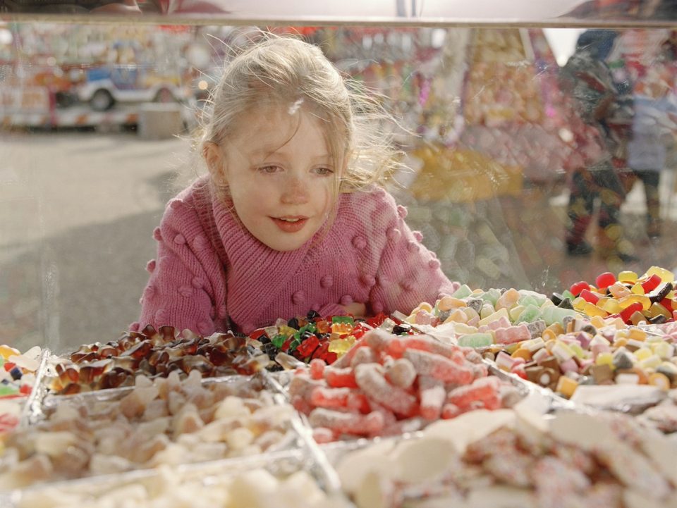 Girl looking at sweets in glass counter