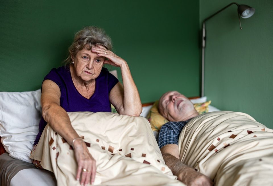 Senior woman can't sleep next to husband in bed