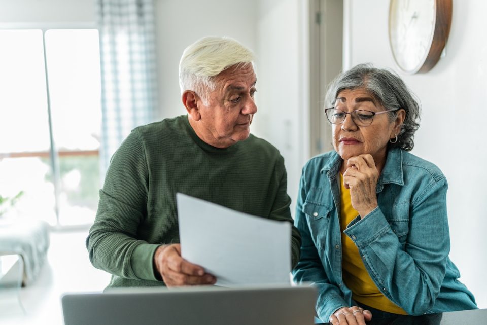 Senior couple using computer and doing home finances at home