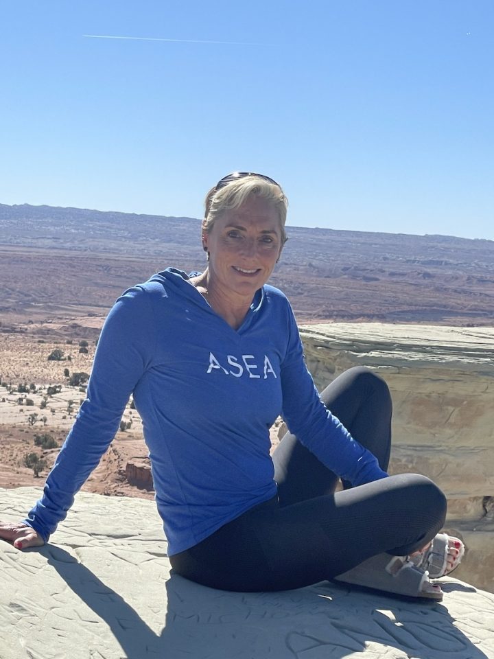 senior blond woman sitting on rock after hike