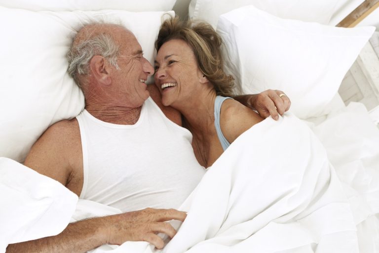 senior couple laughing in bed